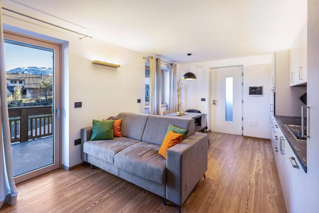 a living room with a couch and a balcony at La Sorgente Ville di Fiemme in Carano