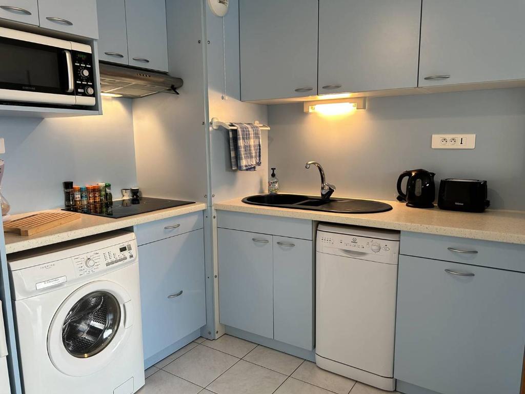 une cuisine avec une machine à laver et un évier dans l'établissement 531 - Appartement T2 vue mer, à 100m de la Plage, à Erquy