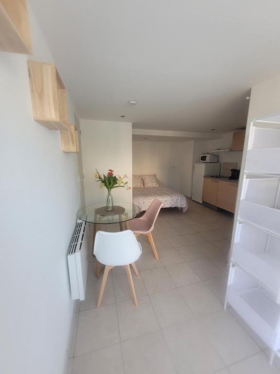 Cette petite chambre comprend une table et un lit. dans l'établissement Studio Corbas, à Corbas