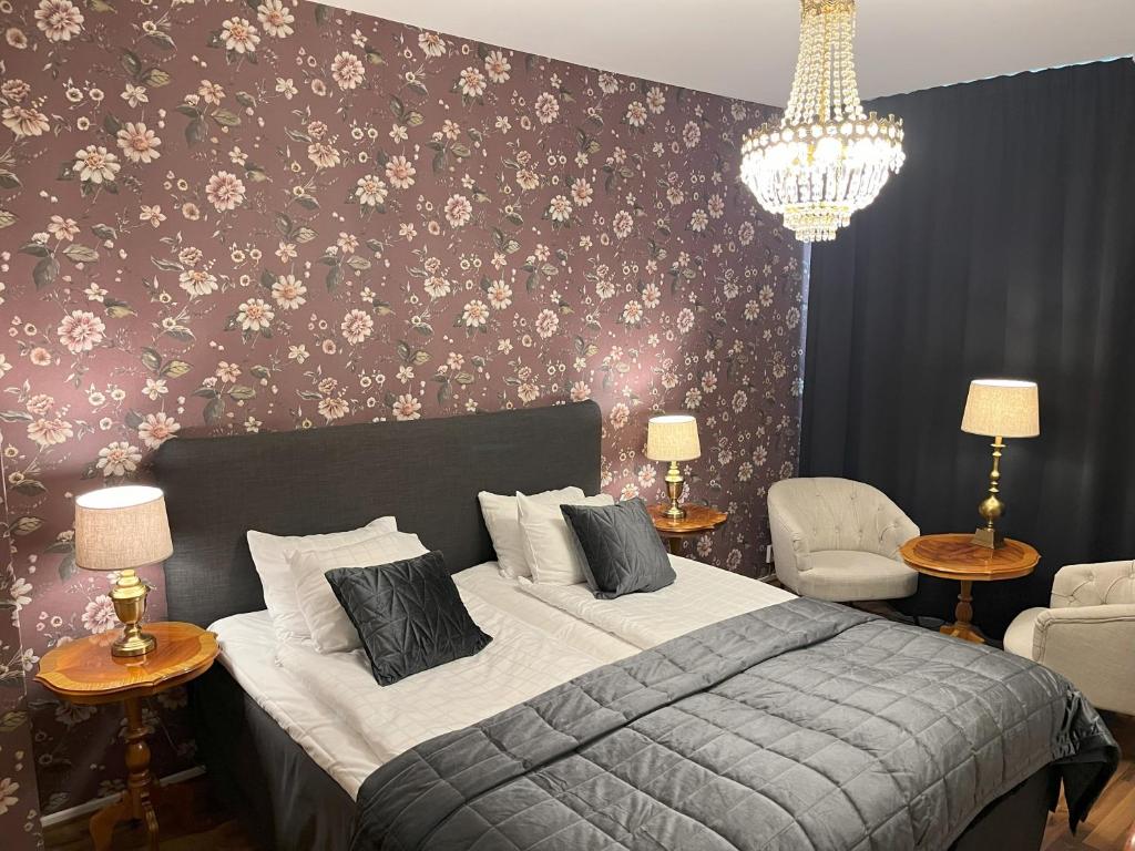 a bedroom with a bed with a floral wall at Hotell Bele in Trollhättan