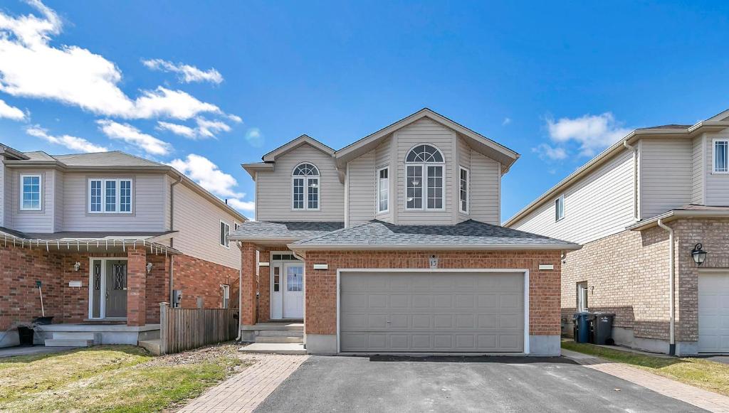 a house with a garage in front of it at Cozy Luxurious Detached 4 Bedroom House in Guelph