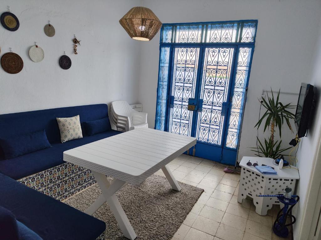 ein Wohnzimmer mit einem blauen Sofa und einem Tisch in der Unterkunft Villa dar nina hergla in Harqalah