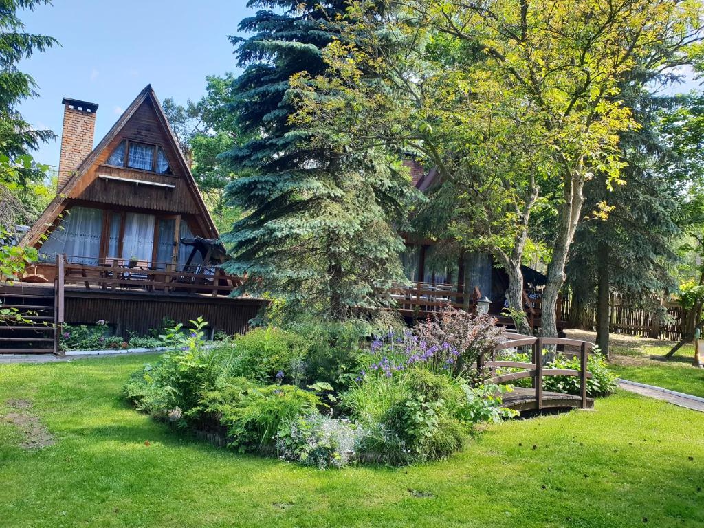a house with a garden in front of it at Hotel Zakątek Leśny in Cierpice