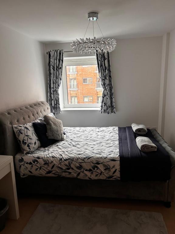 a bedroom with a bed and a window at City Centre apartment. in Wrexham