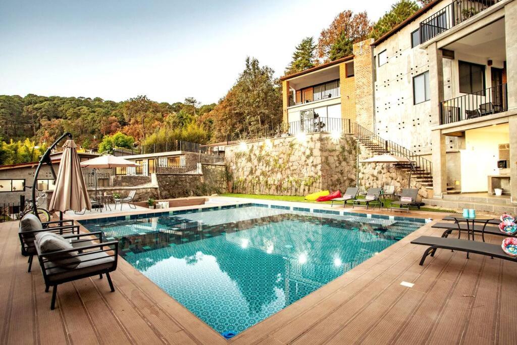 a swimming pool in the middle of a house at La Fábrica #1 Carrie Furnace in Valle de Bravo