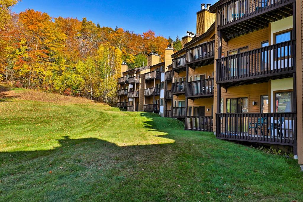 una fila de edificios de apartamentos con árboles en el fondo en Okemo Mountain Lodge en Ludlow