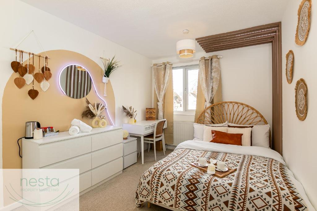 1 dormitorio con cama, escritorio y espejo en Bohemian Haven Guesthouse, en Oxford