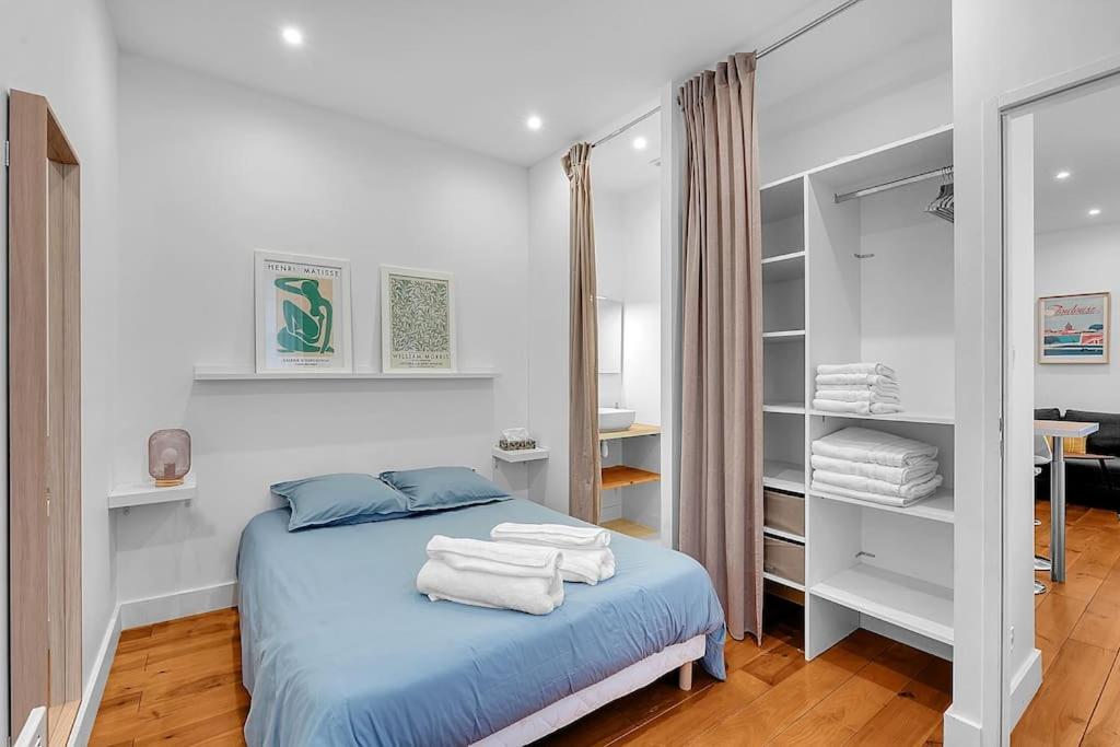 1 dormitorio con 1 cama con toallas en Le Cocon - T2 Cosy hypercentre avec parking, en Toulouse