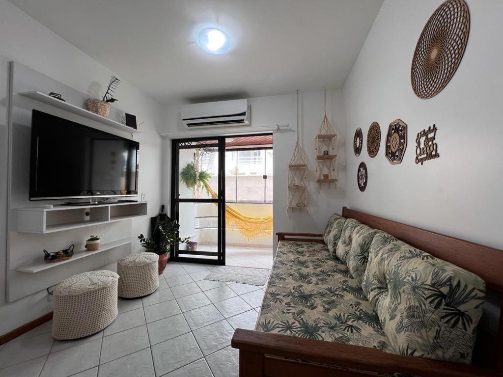 un soggiorno con divano e TV a schermo piatto di Apartamento beira mar a Florianópolis