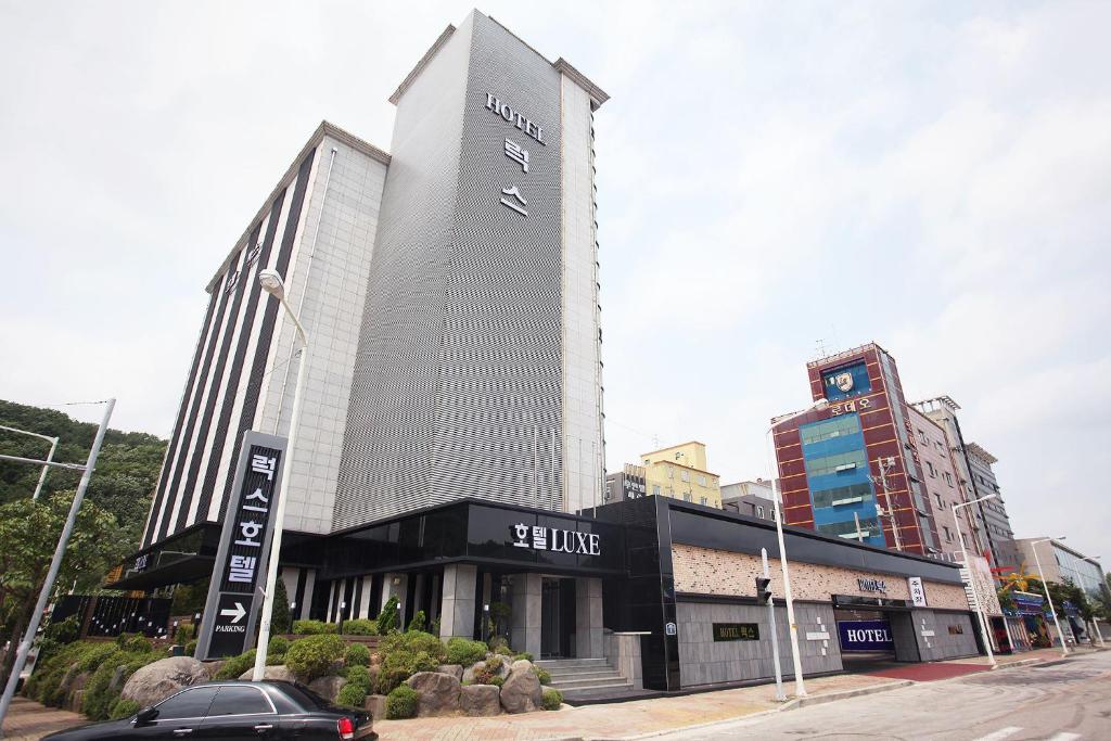 a large building with a sign on the side of it at Luxe Hotel in Paju