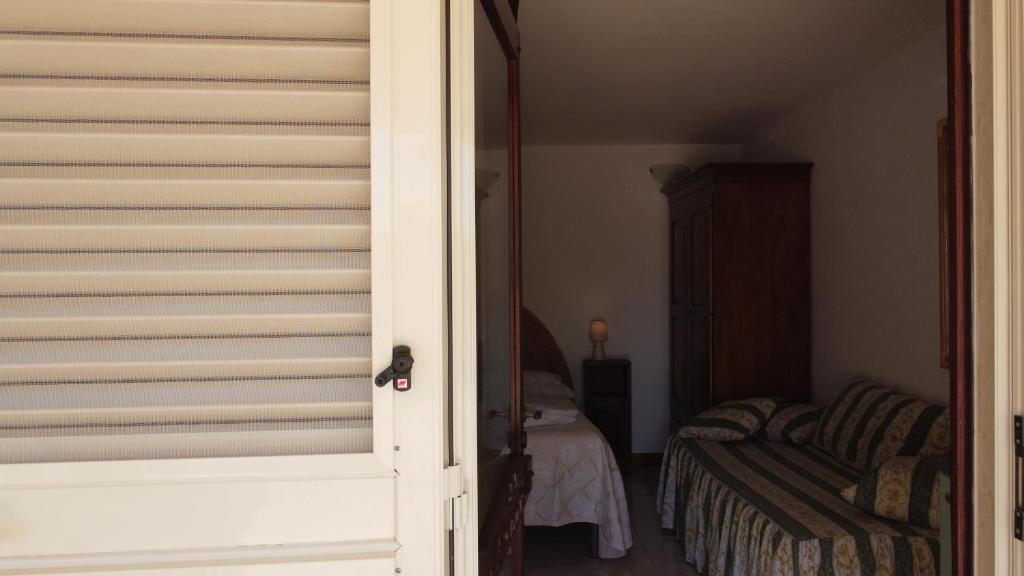Una puerta que conduce a un dormitorio con cama en My Home - Laguna, en Porto Cesareo