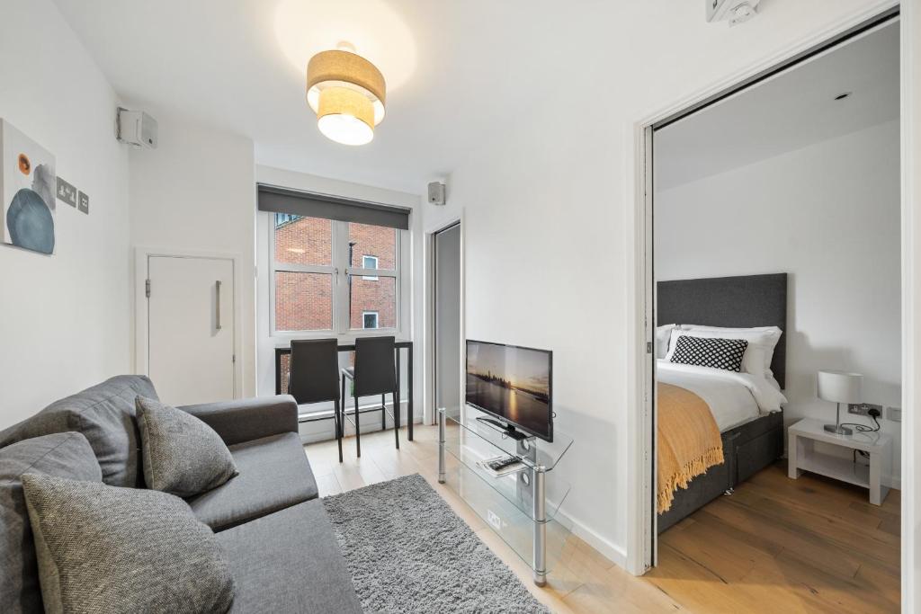 uma sala de estar com uma cama e um espelho grande em Modern 1 Bed Apartment Camden em Londres