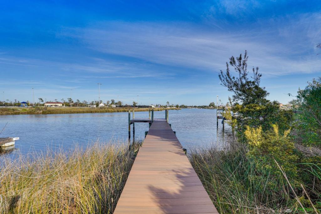 a wooden dock in the middle of a body of water at Panama City Waterfront Escape Fenced Yard and Dock! in Panama City