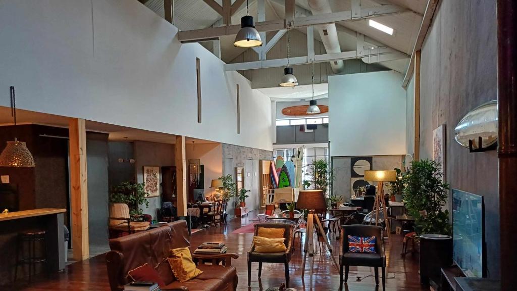 una sala de estar con muchas sillas y mesas en Caruma Surf Hostel, en Matosinhos