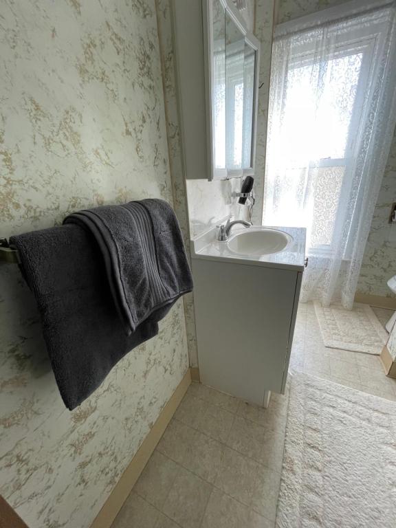 a white bathroom with a sink and a mirror at 3 Bed House in Niagara Falls in Niagara Falls