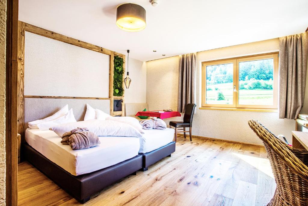 a bedroom with a bed and a desk and a window at Hundehotel Riederhof in Ried im Oberinntal