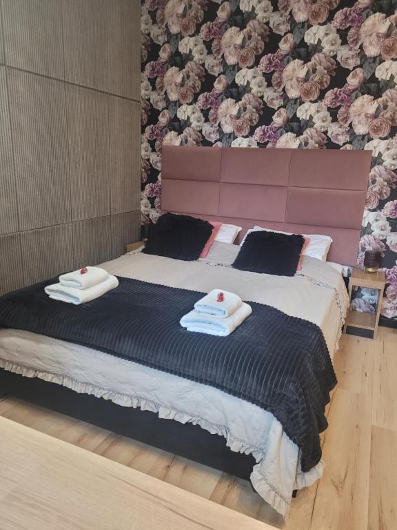 a bedroom with a large bed with two towels on it at Apartament w sercu Elbląga in Elblag