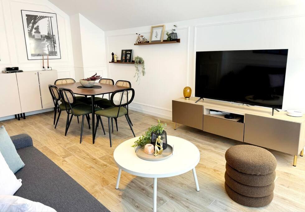 a living room with a table and a large television at New Disneyland Paris Serena Apartment in Bussy-Saint-Georges
