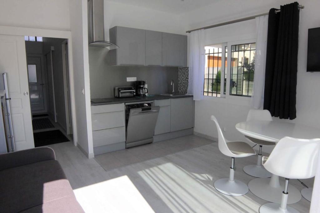 a kitchen with a table and a table and chairs at Maison hôtes près de Disneyland Paris in Lagny