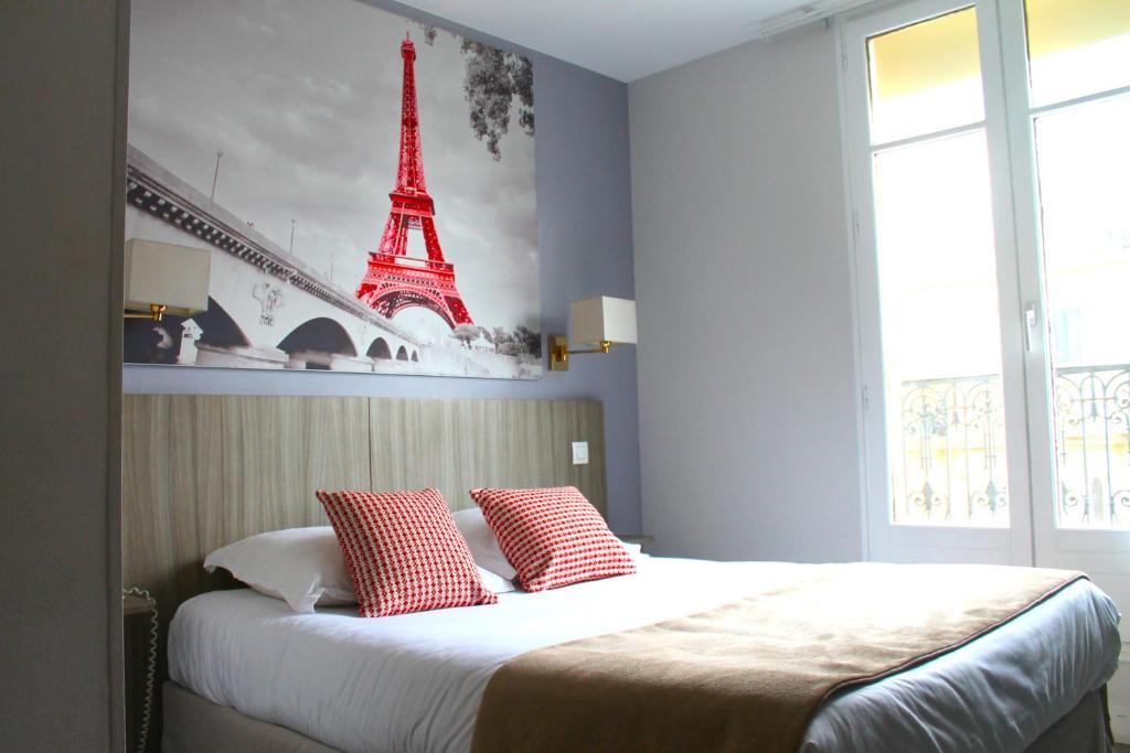 um quarto com uma cama com um quadro da Torre Eiffel em Avia Hôtel Saphir Montparnasse em Paris