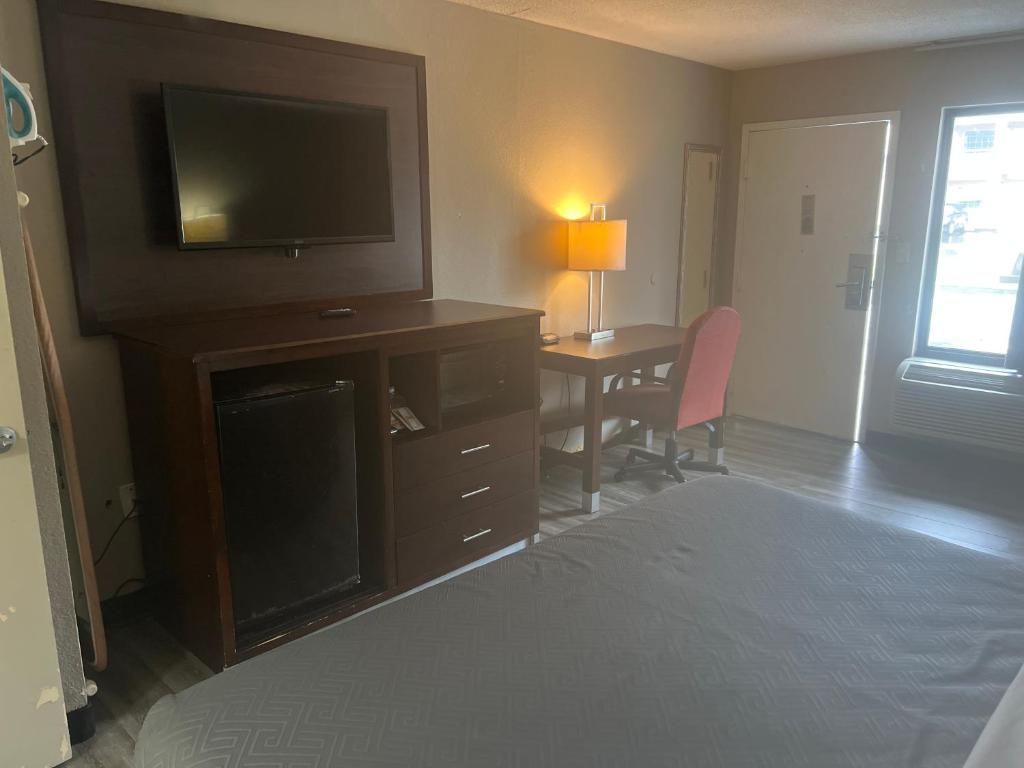 a bedroom with a bed and a desk with a television at Econo Lodge in Florence