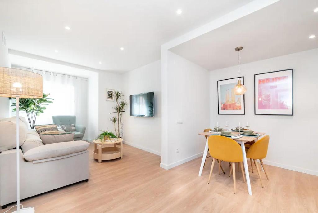 a white living room with a table and a couch at Soler Apartments in Sant Adria de Besos