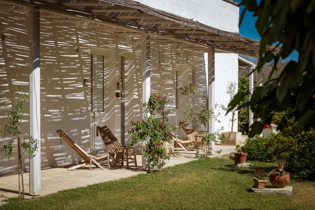 a patio with rocking chairs and a house at Masseria Rauccio in Torre dell'Orso
