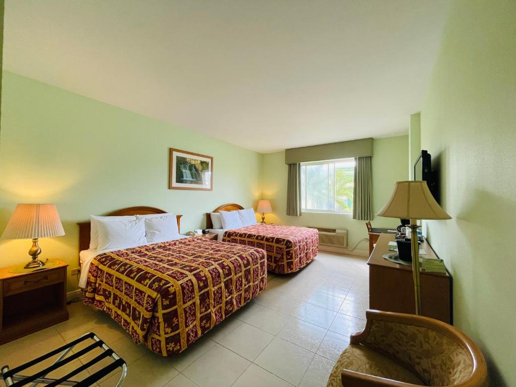 a hotel room with two beds and a chair at Princess Vegas Hotel & Casino in Corozal