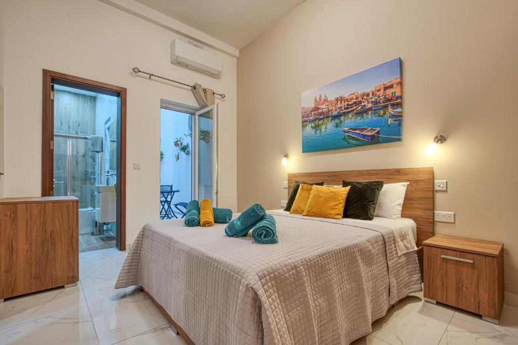ein Schlafzimmer mit einem Bett und einem Wandgemälde in der Unterkunft Aloha - Village Apartment 2 BR in Mellieha in Mellieħa