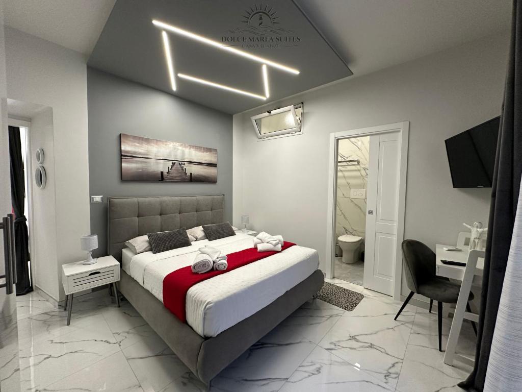 a bedroom with a large bed and a bathroom at Dolce Marea Suites in Licata