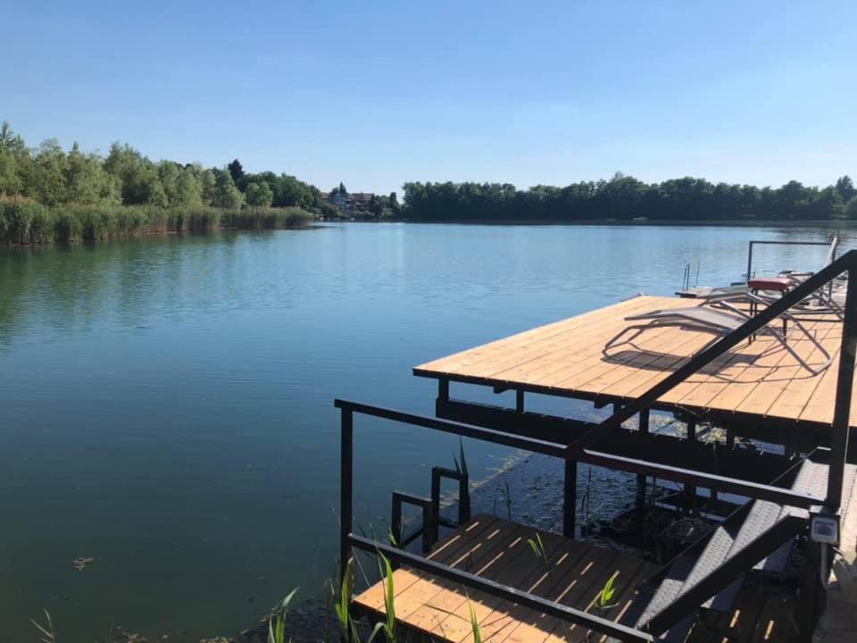 a dock in the middle of a lake at Tópart Nyaralóház Gyékényes in Gyékényes