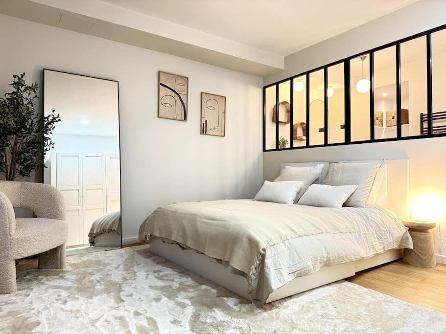 une chambre blanche avec un lit et une chaise dans l'établissement Acogedor apartamento en el centro de París., à Paris