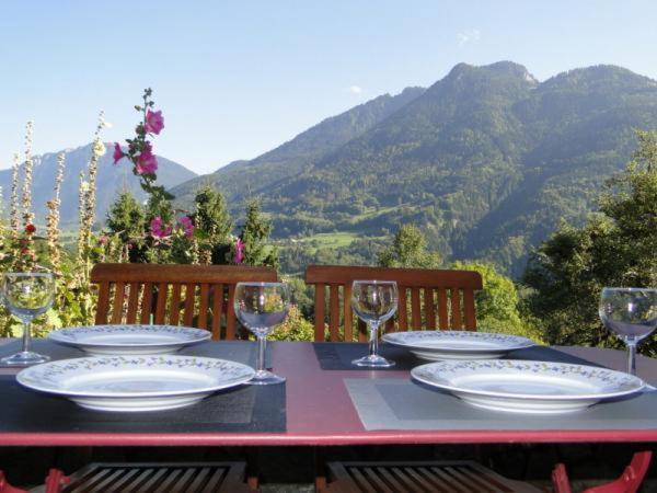 un tavolo con piatti e bicchieri da vino in cima a una montagna di Gite le Pré de Lamia a Chevenoz