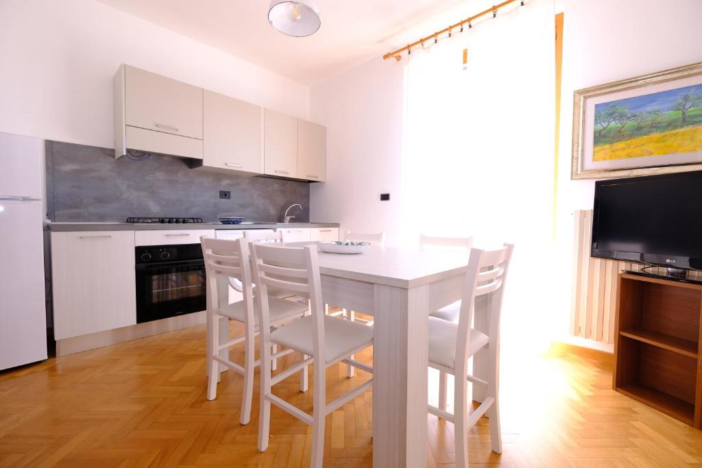 - une cuisine blanche avec une table et des chaises blanches dans l'établissement Lady - Pineto Vacanza, à Pineto