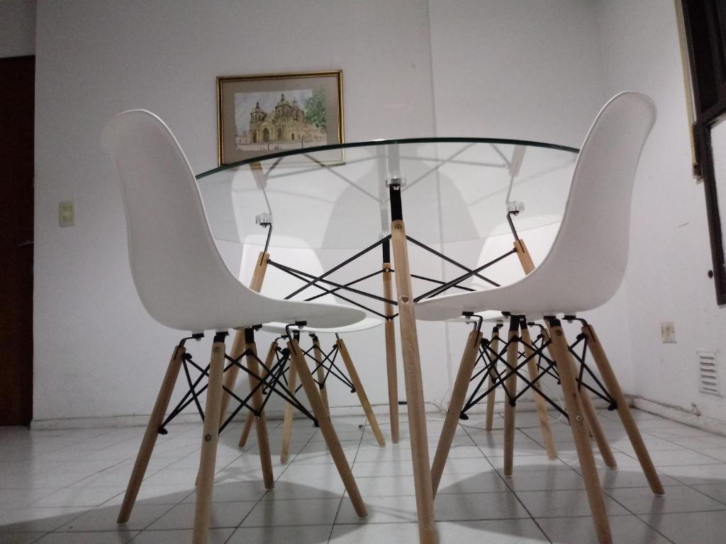 dos sillas blancas sentadas bajo una mesa de cristal en Obispo Trejo en Córdoba