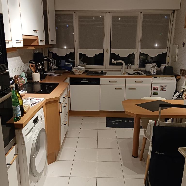 une cuisine avec une machine à laver et une table dans l'établissement OREE DE MARLY, à Noisy-le-Roi