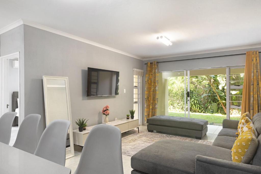 a living room with a couch and a tv at Kingston Estate 112 by HostAgents in Ballito