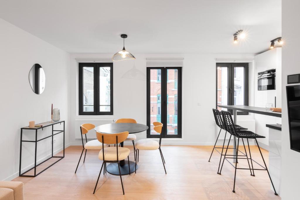 NEW apartment. UE - City center في بروكسل: مطبخ وغرفة طعام مع طاولة وكراسي