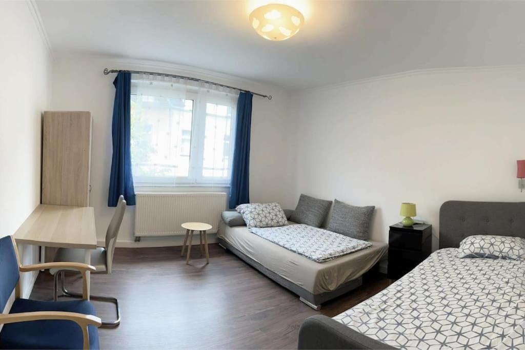 1 dormitorio con cama, sofá y mesa en 2-Schlafzimmer-Wohnung mit Parkplatz-Balkon-Küche- Garten, Nahe DUS Airport, Messe, en Duisburg