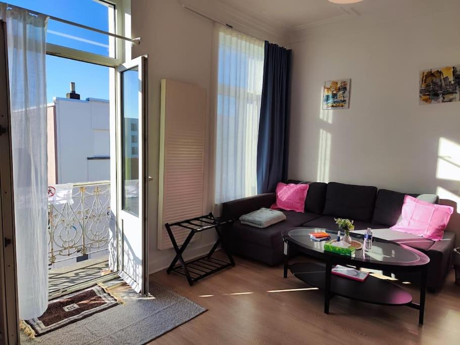 sala de estar con sofá y mesa en Studio entier avec balcon - Tour et Taxis en Bruselas