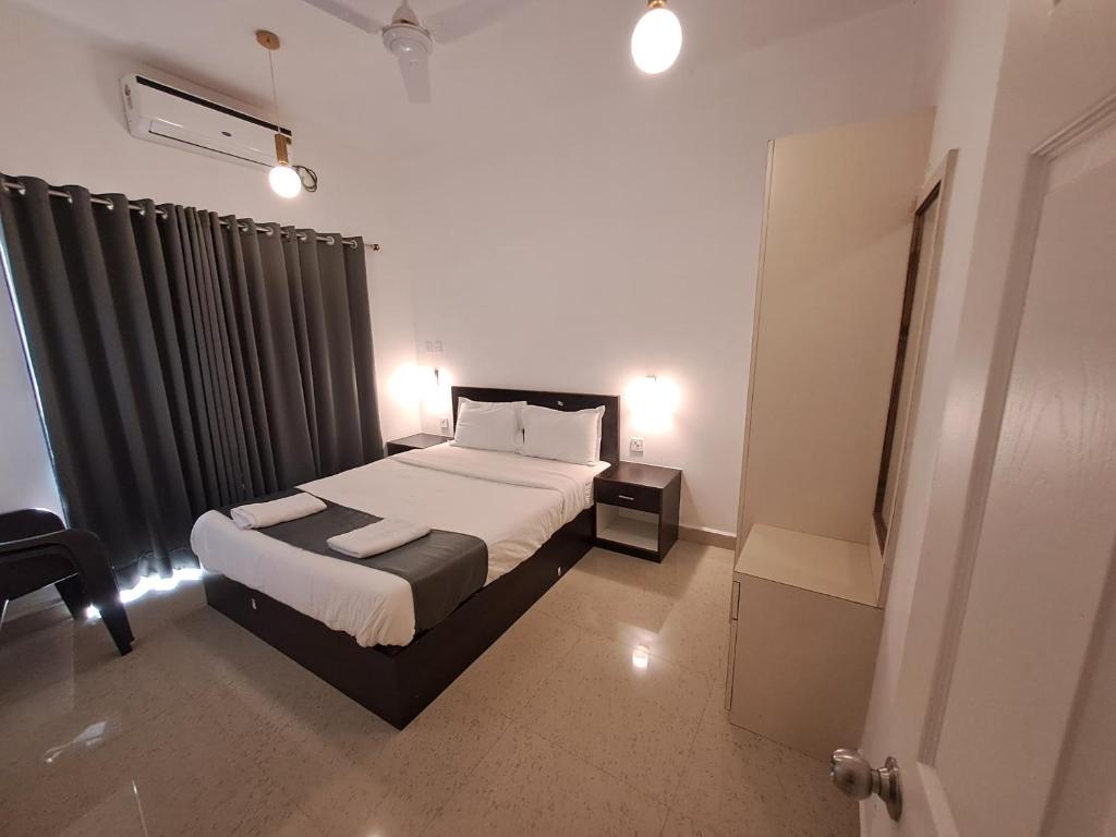 a bedroom with a large bed and a window at Hotel RSA Residency in Pernem