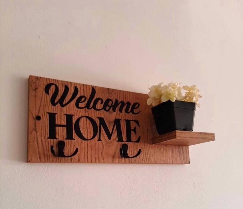 a welcome home sign on a wall with a plant at Apartamento los Aces in Ricaurte