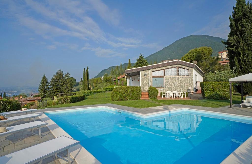 une grande piscine en face d'une maison dans l'établissement Villa Laura, à Toscolano Maderno