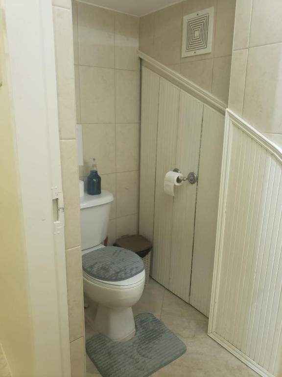 a small bathroom with a toilet and a door at Noud Villa in Santa Cruz
