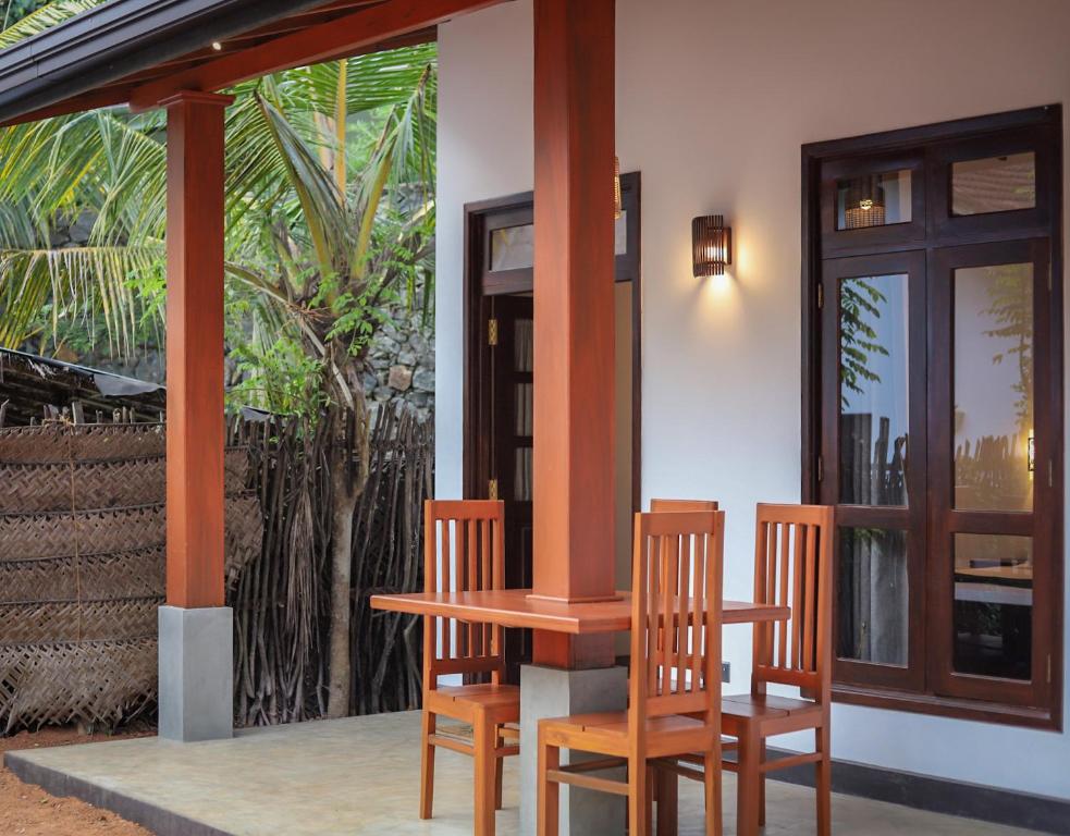 2 sillas y una mesa en el porche de una casa en Ran Villa en Hiriketiya