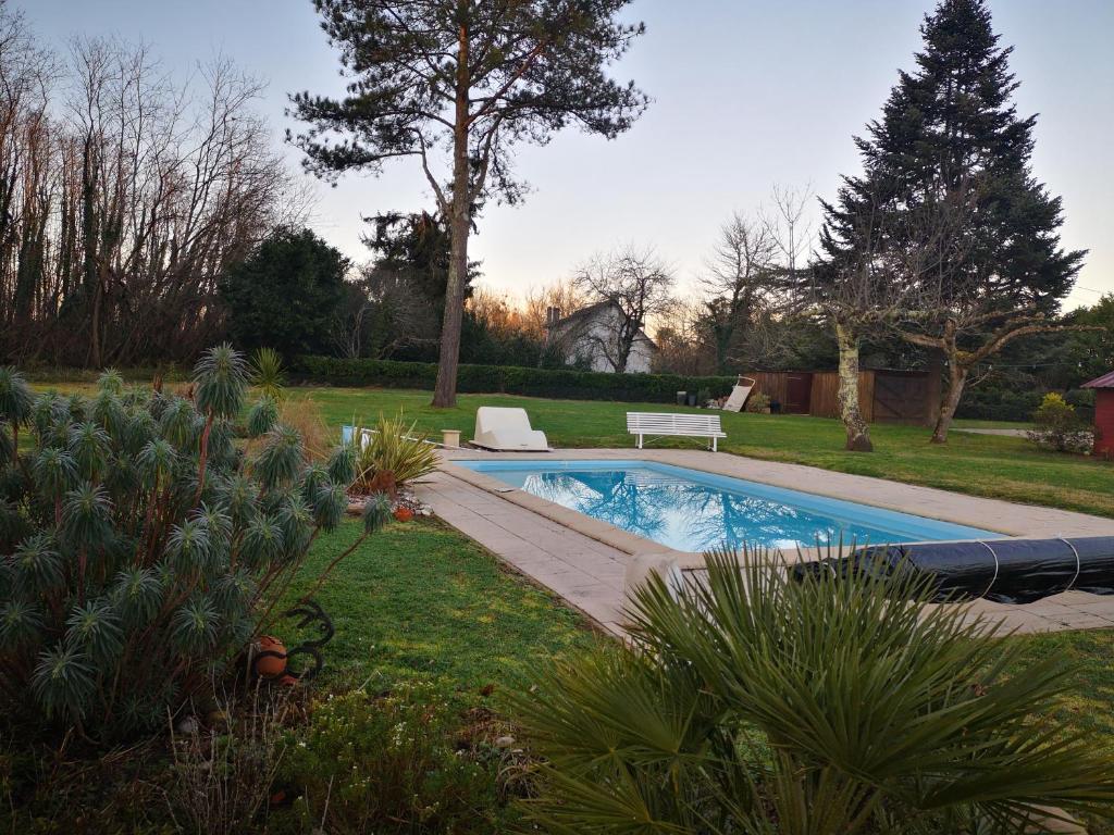 una piscina en un patio con jardín en gite, en Illats