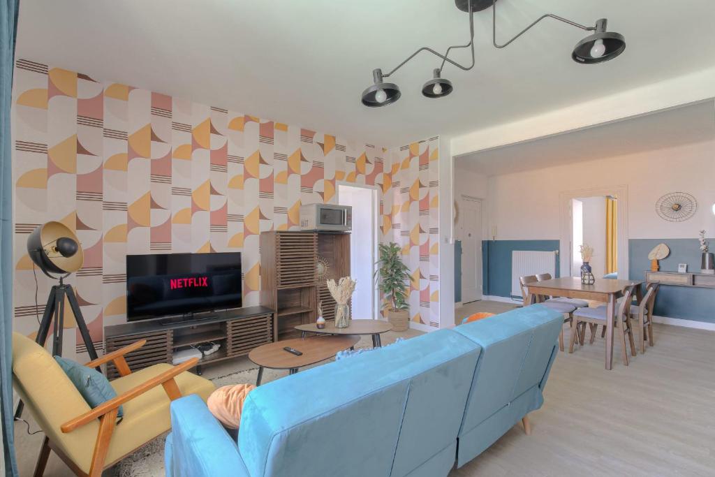 un salon avec un canapé bleu et une télévision dans l'établissement Design et Convivial avec parking gratuit, à Villeurbanne