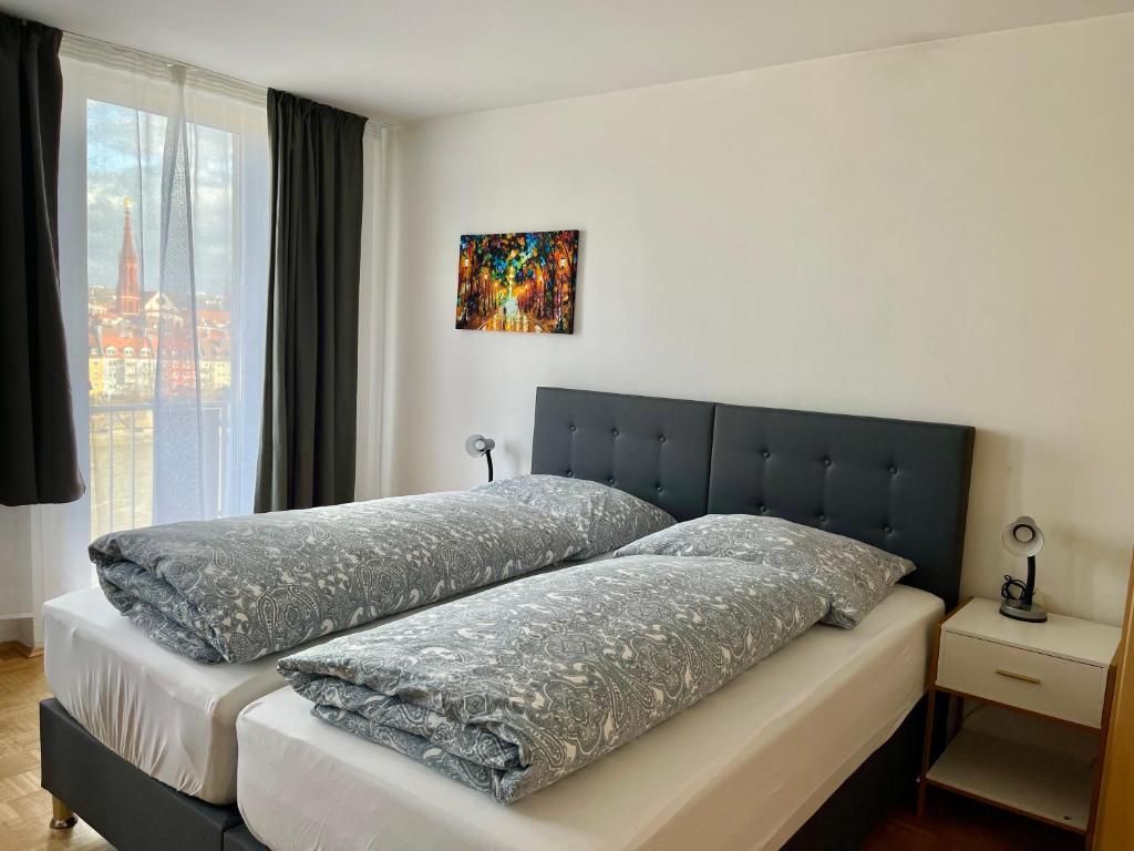 a bed in a bedroom with a large window at Etzel Ferienwohnung (Main Riverview) in Würzburg