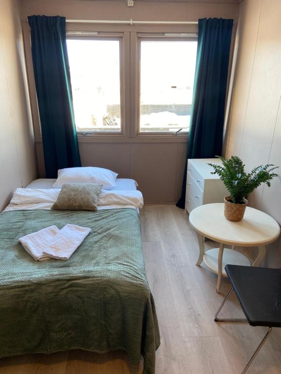 a bedroom with a bed and a table and a window at Spørkel Landbruk in Lier