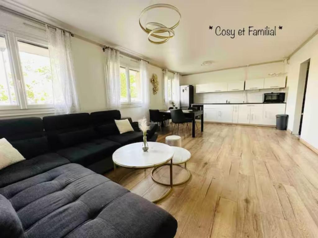een woonkamer met een bank en een tafel bij Appt 70M2 Cosy et Famillial proche Paris in Ermont